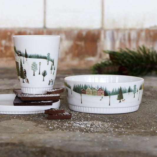 Ceramic cup and bowl with nature-themed design on a stone surface