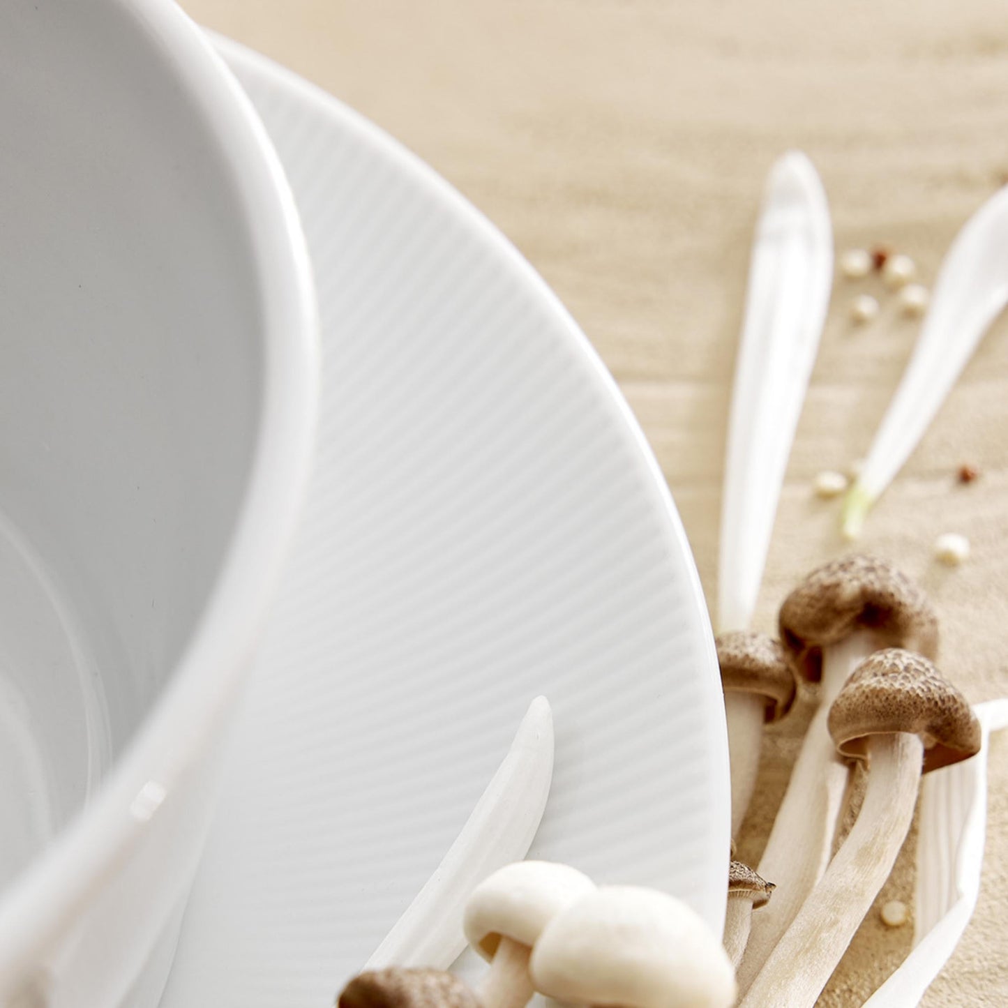 Close-up of a white plate with mushrooms on a beige background