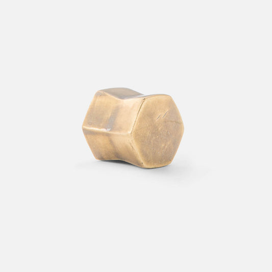 A single white hexagon-shaped cabinet knob against a white background.