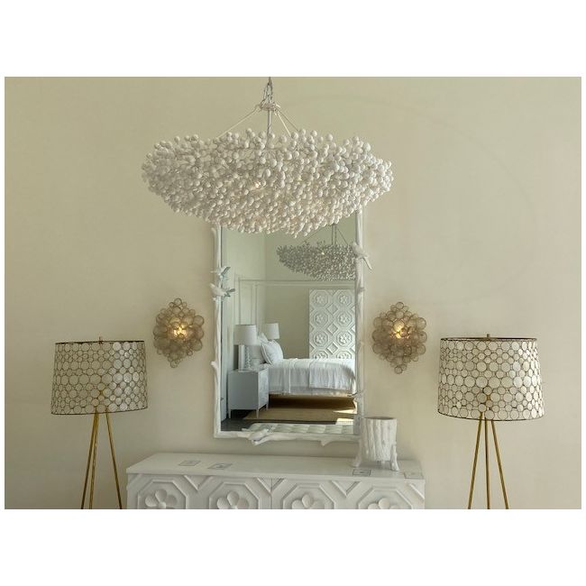 Decorative chandelier, mirror, and lamps in a room setting.