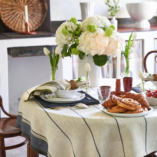 Dining table set with flowers, plates, and pastries in a home setting.