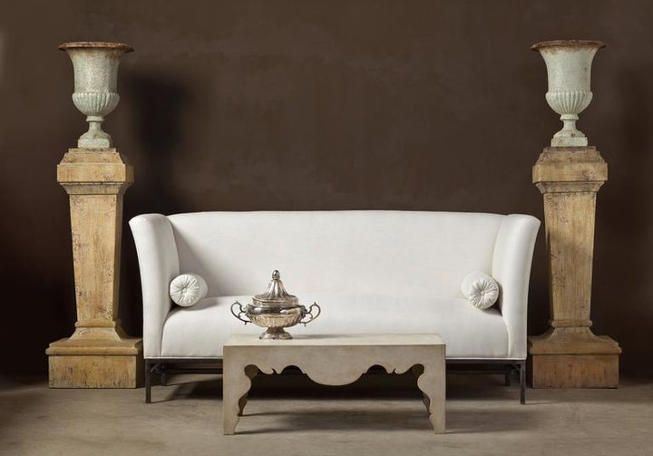 Contemporary Rococo Coffee Table in Painted Swedish Finish by Tara Shaw pictures with white sofa and two pillars with white urns sitting on top