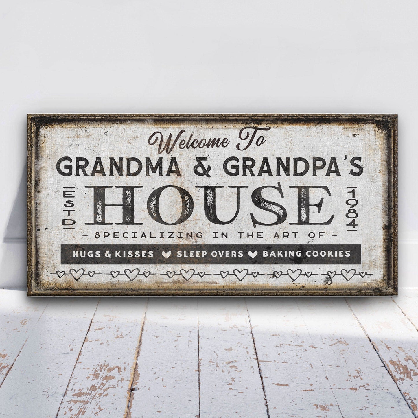 Decorative sign reading 'Welcome to Grandma & Grandpa's House' on a white wooden floor.