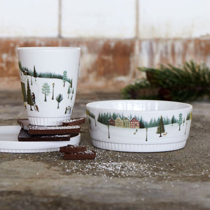 Ceramic cup and bowl with nature-themed design on a stone surface
