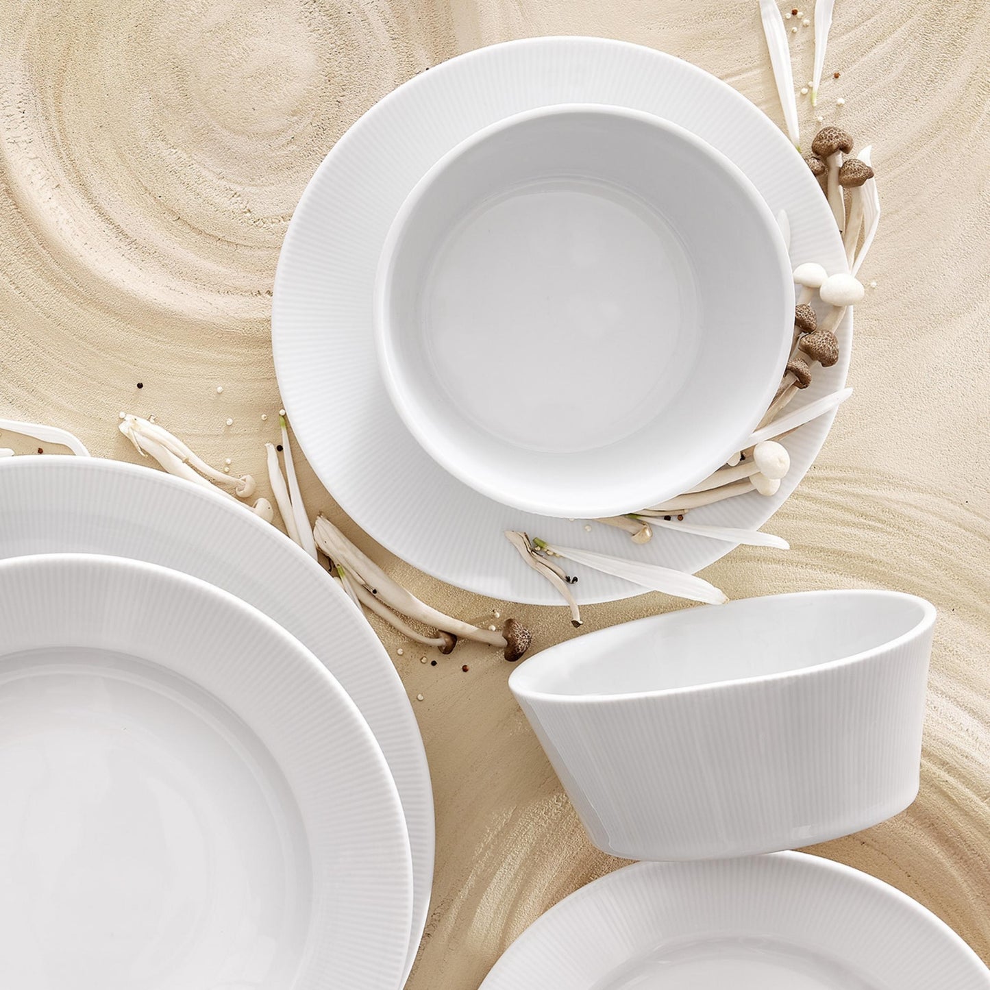 Set of white ceramic dishes on a wooden surface