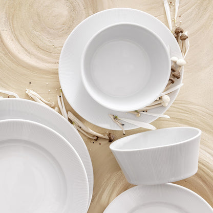 Set of white ceramic dishes on a wooden surface