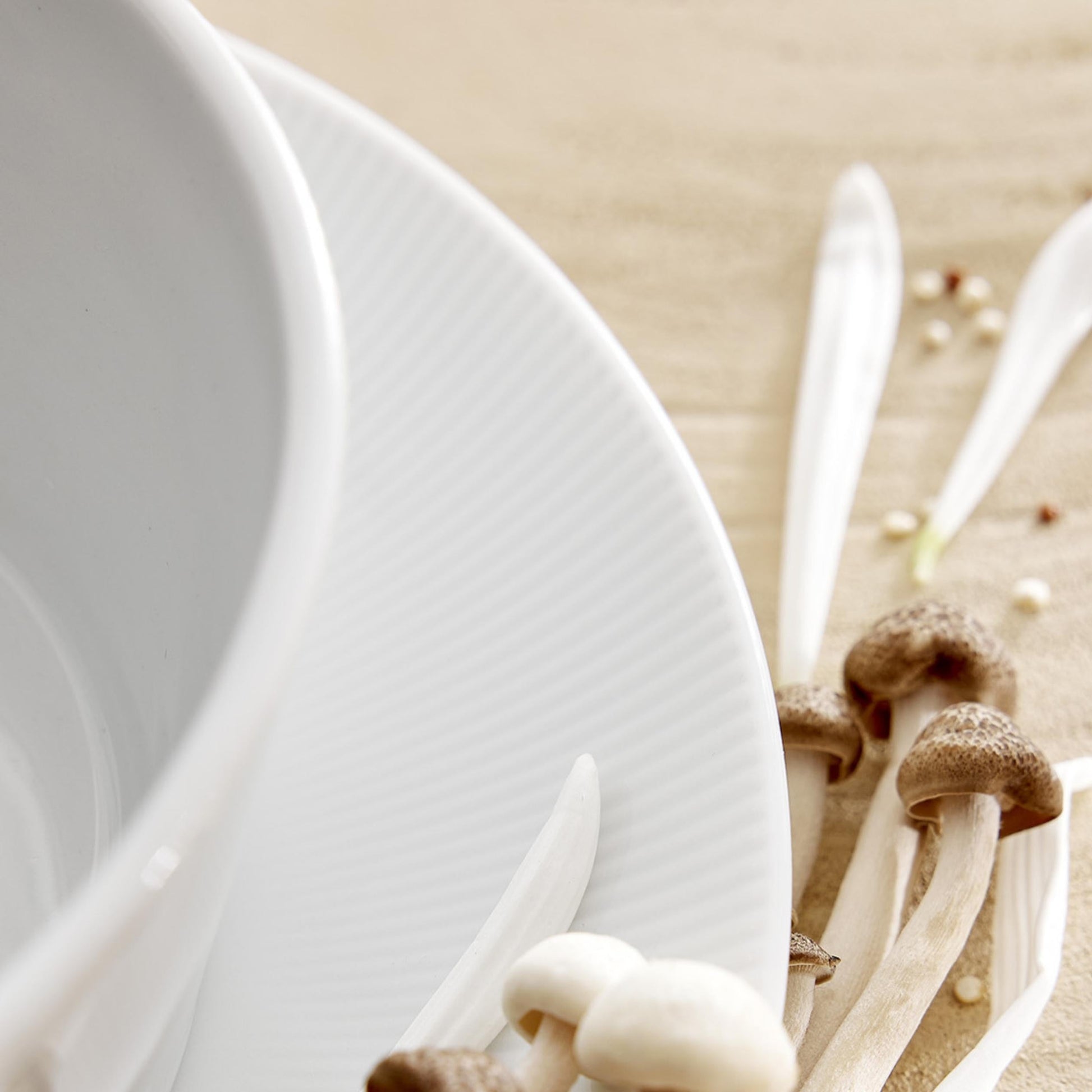 Close-up of a white plate with mushrooms on a beige background