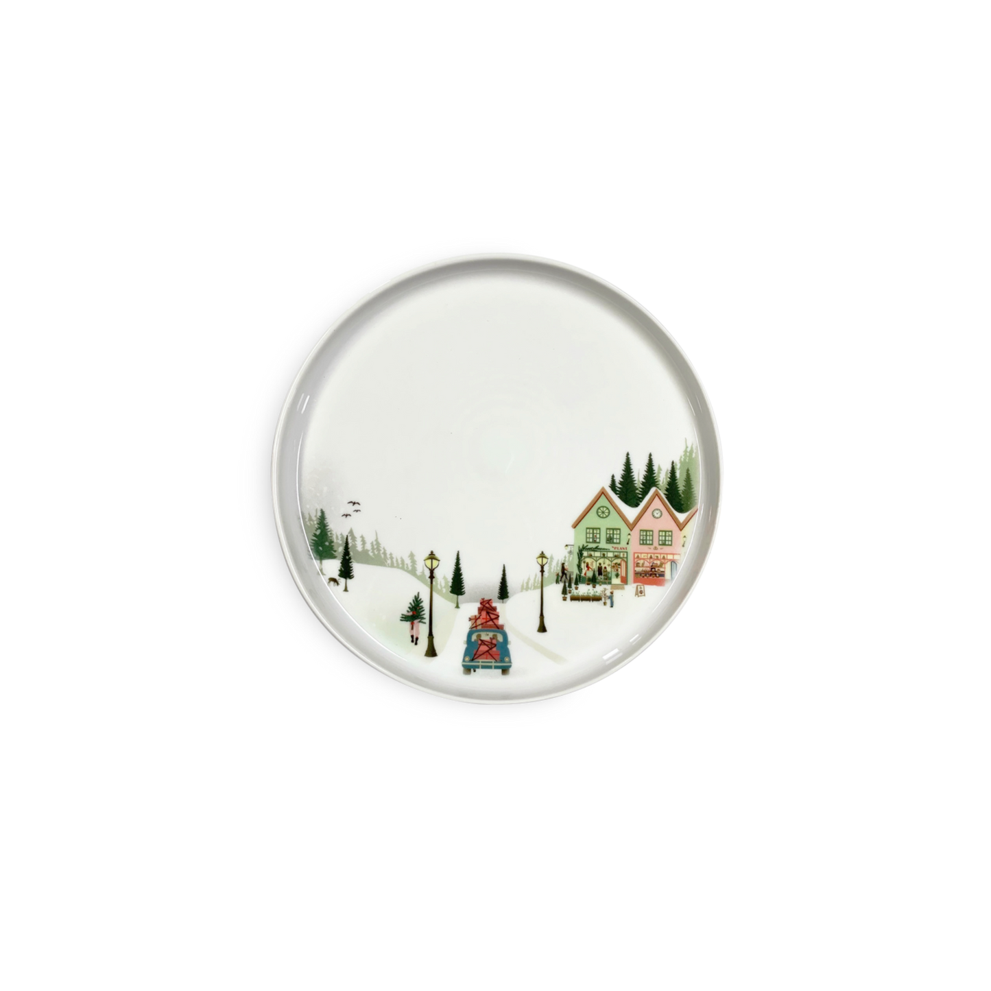 Round ceramic plate with a winter scene design featuring houses and trees on a white background