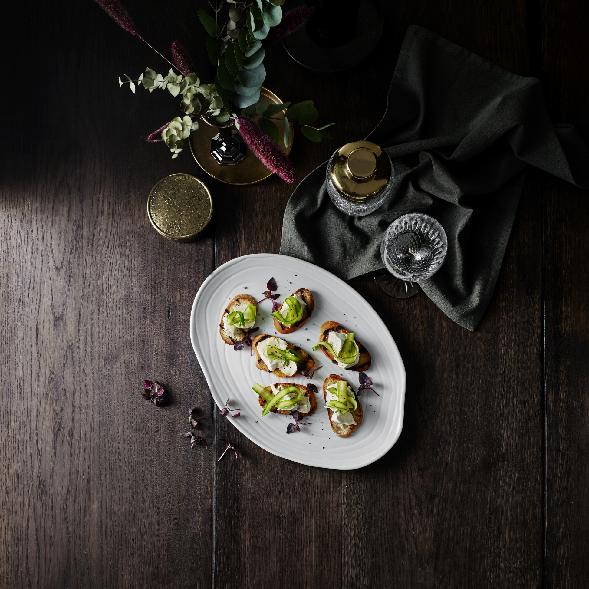 Platter of appetizers on a dark wooden table with decorative elements.