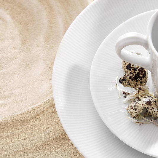 White ceramic plate with a small dish of food on a beige surface