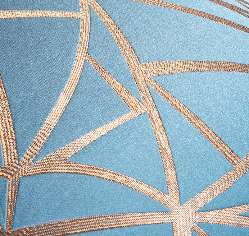 Close-up of geometric pattern on fabric with blue background