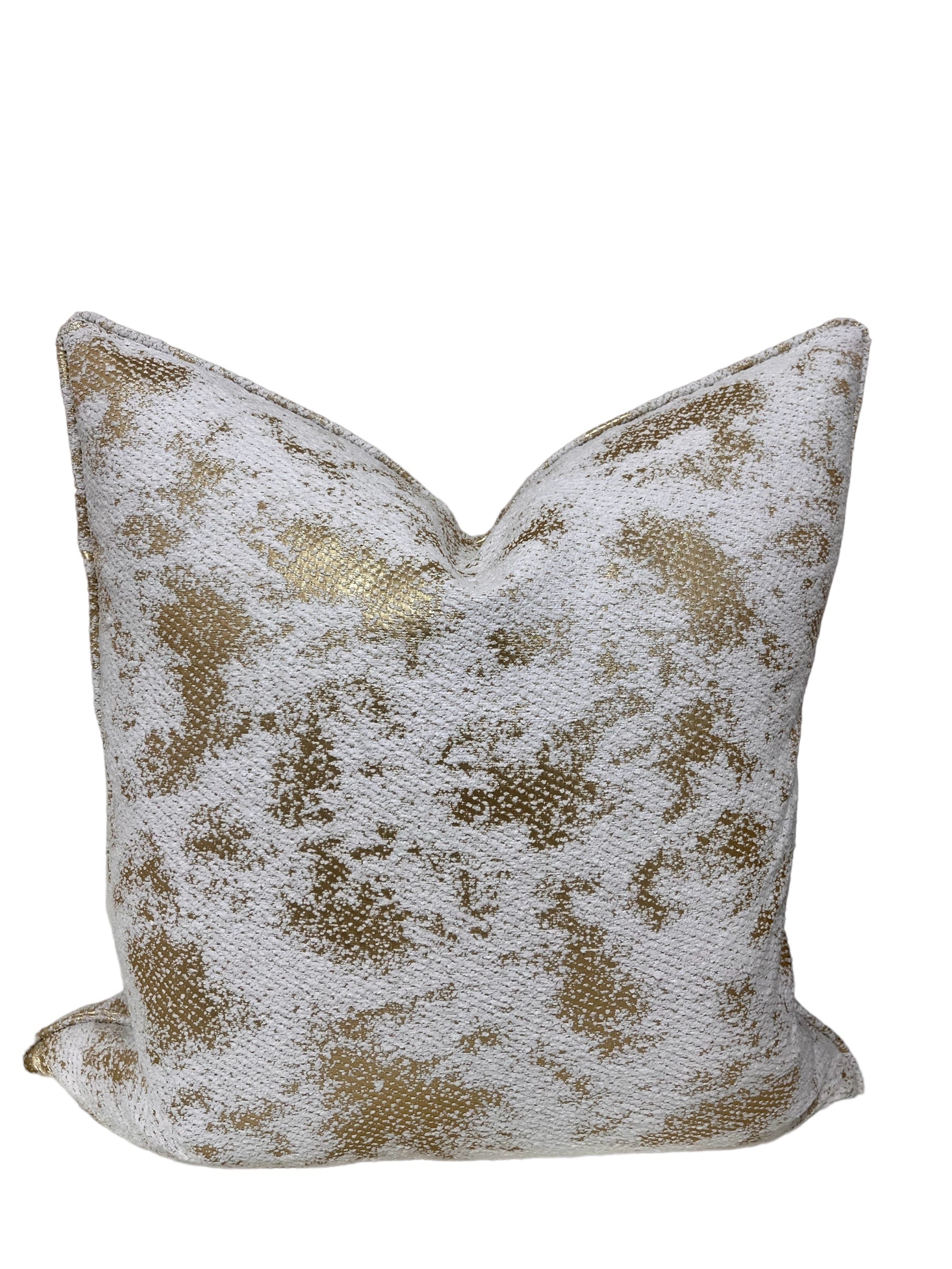 Decorative throw pillow with gold and white pattern on a white background