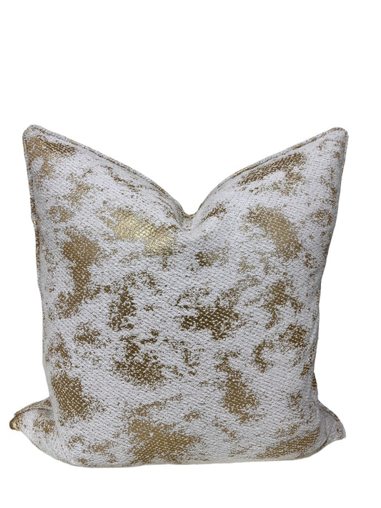 Decorative throw pillow with gold and white pattern on a white background