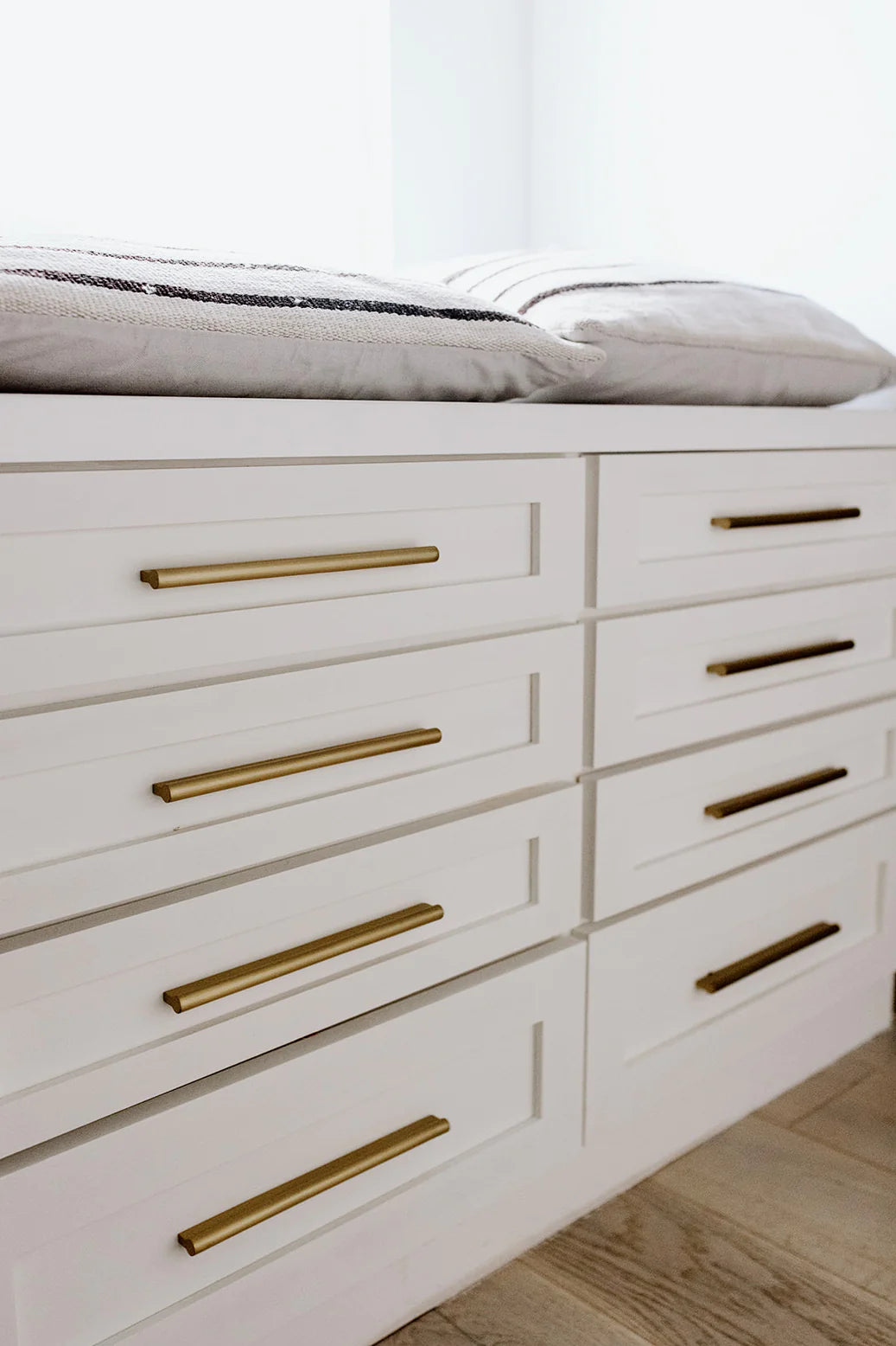 Modern brass drawer pull installed on wood cabinet