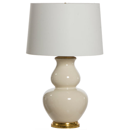 A table lamp with a white shade and a base with a gold-colored accent at the bottom. The base is more SW6420 Queen Anne's Lace than the beige color pictured.