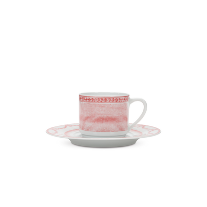 Ceramic cup and saucer with red and white pattern on a white background