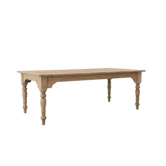 A wooden dining table with a rectangular top and turned legs, with a lightly washed finish. Sideview