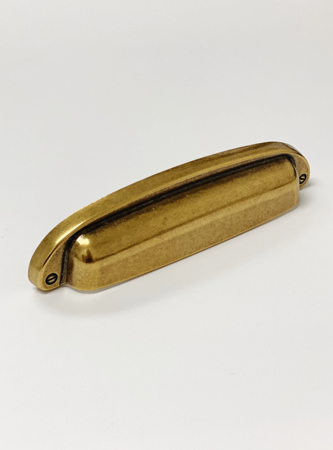 Gold-colored metal handle on a white background