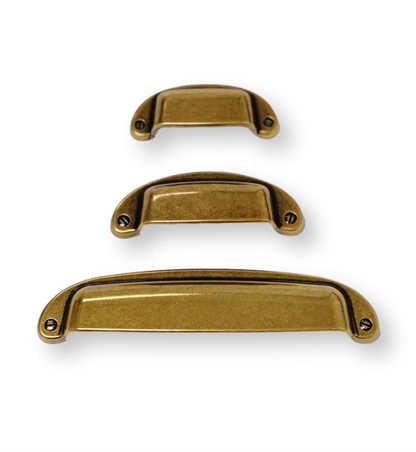 Three gold cabinet handles of different sizes on a white background