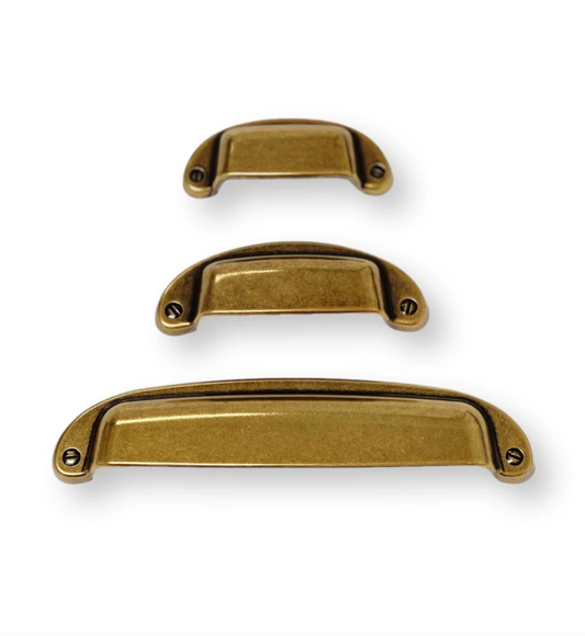Three gold cabinet handles of different sizes on a white background