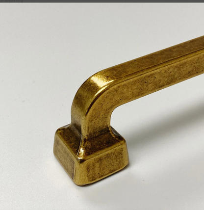 Gold cabinet handle on a white background
