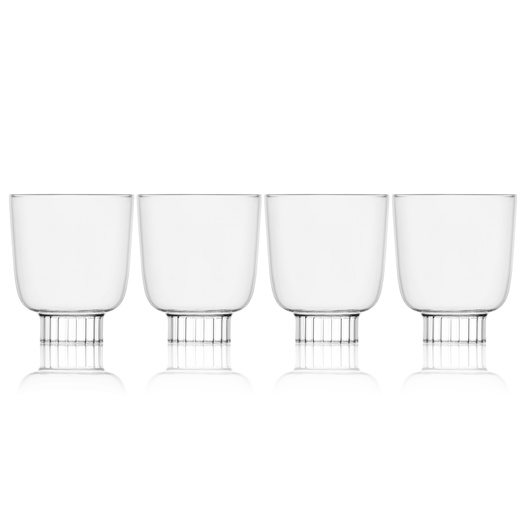 Set of four clear glass tumblers with metal bases on a white background