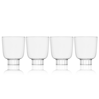 Set of four clear glass tumblers with metal bases on a white background