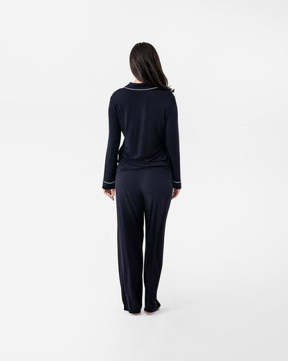 Person wearing a black outfit with a white trim on a white background