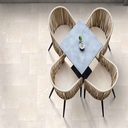 Dining table set with four wicker chairs on a tiled floor