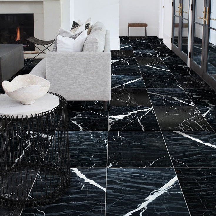 Black marble tiles with white veins in a modern living room setting.