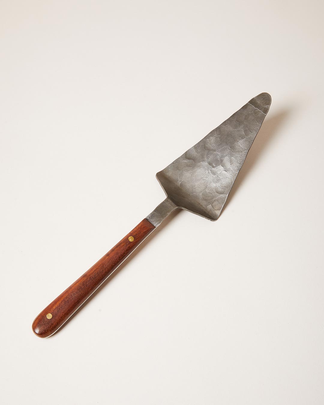 Metal cake server with wooden handle on a white background