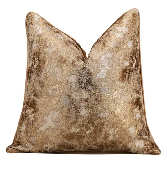 Gold and bronze patterned throw pillow on a white background