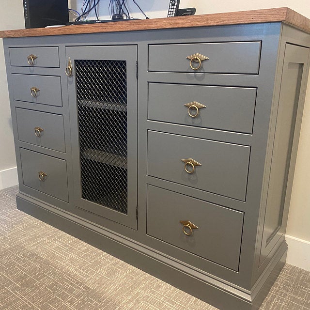 Gray dresser with gold handles on a carpeted floor
