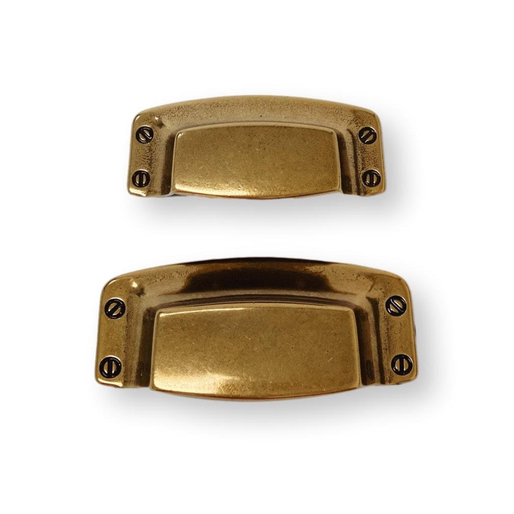 Two brass cabinet handles on a white background