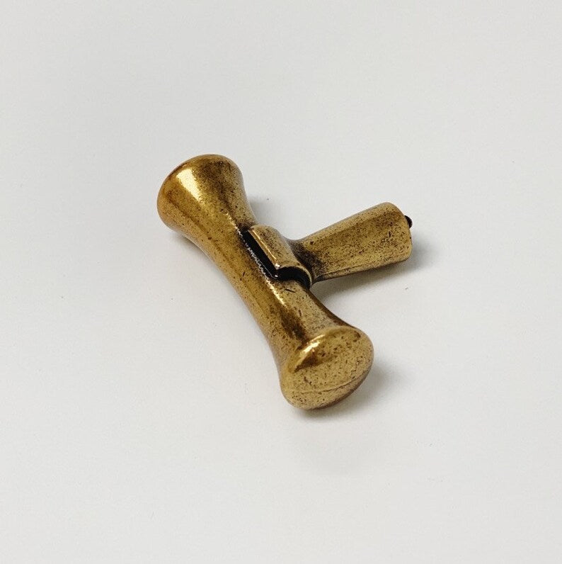 Gold-colored metal toggle on a white background