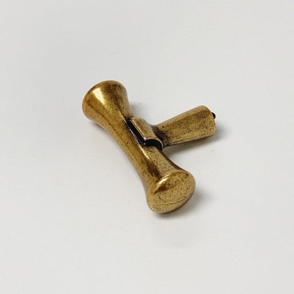 Gold-colored metal toggle on a white background