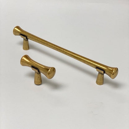 Two gold cabinet handles on a white background