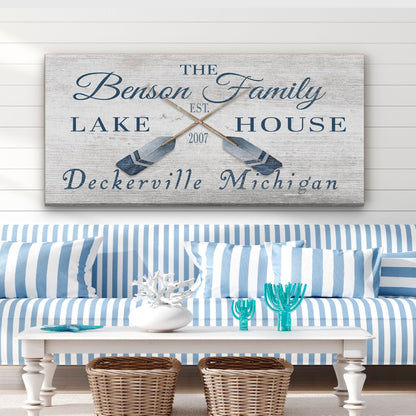 Decorative sign with 'The Benson Family Lake House' on a wall above a blue and white striped sofa.