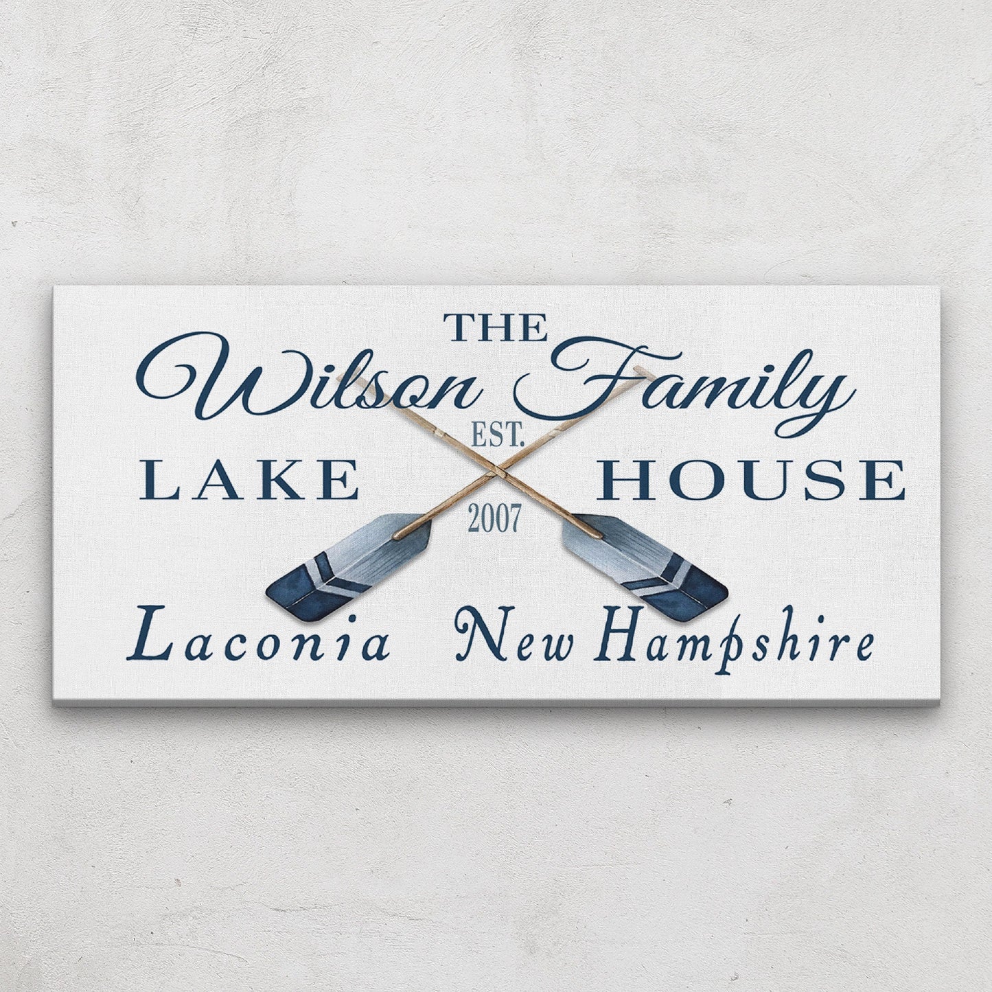 Personalized lake house sign with oar designs on a light gray background