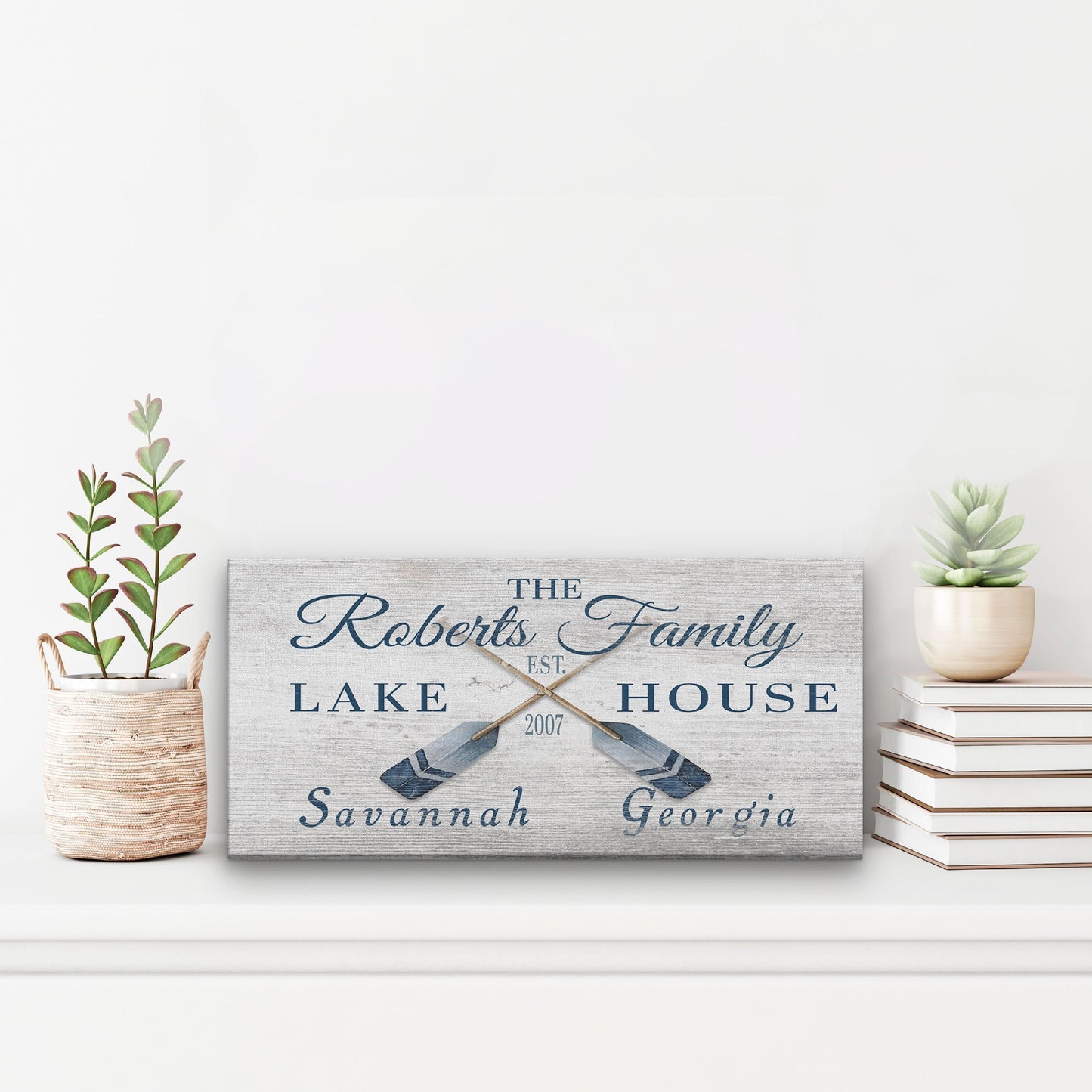 Personalized lake house sign with decorative elements on a white surface.
