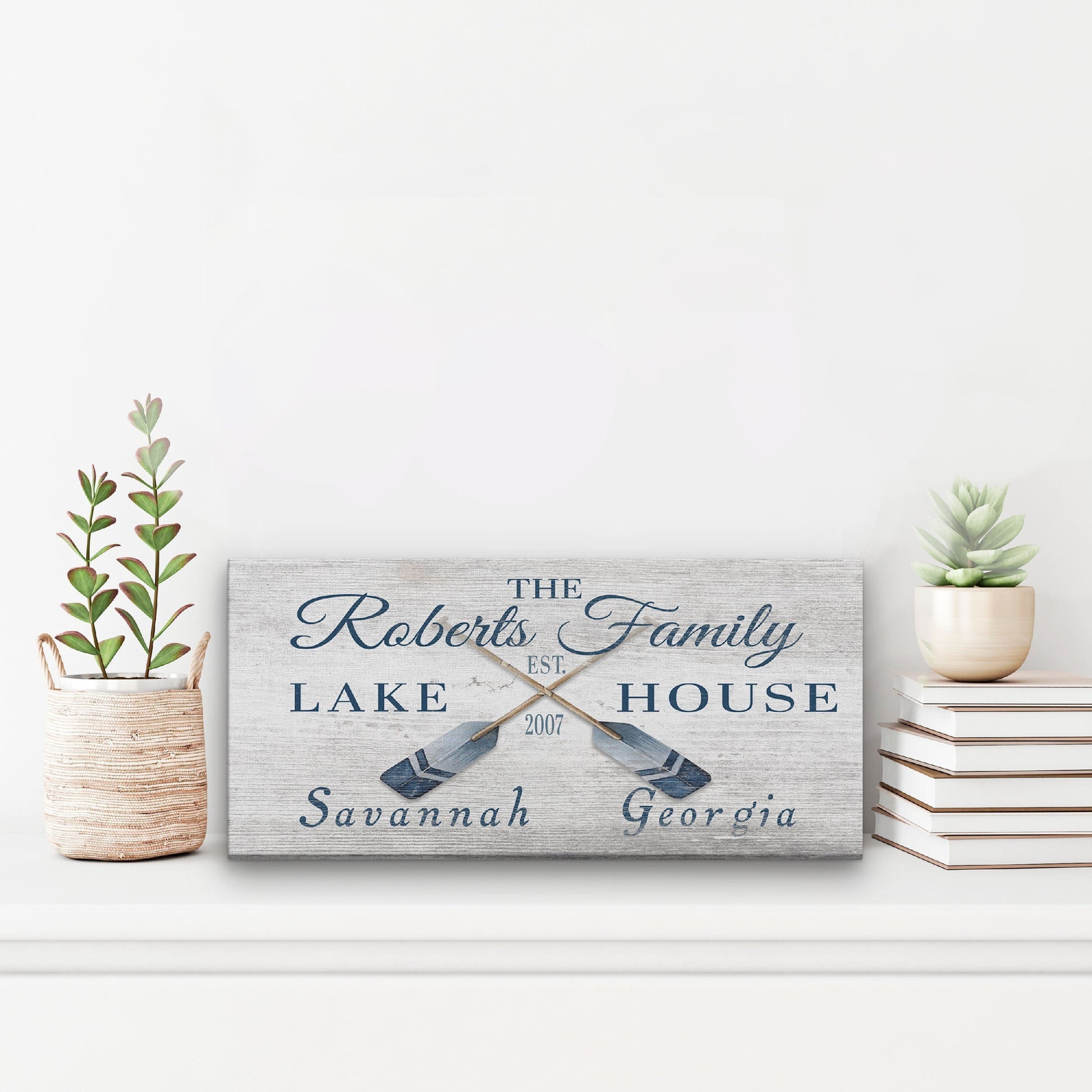 Personalized lake house sign with decorative elements on a white surface.