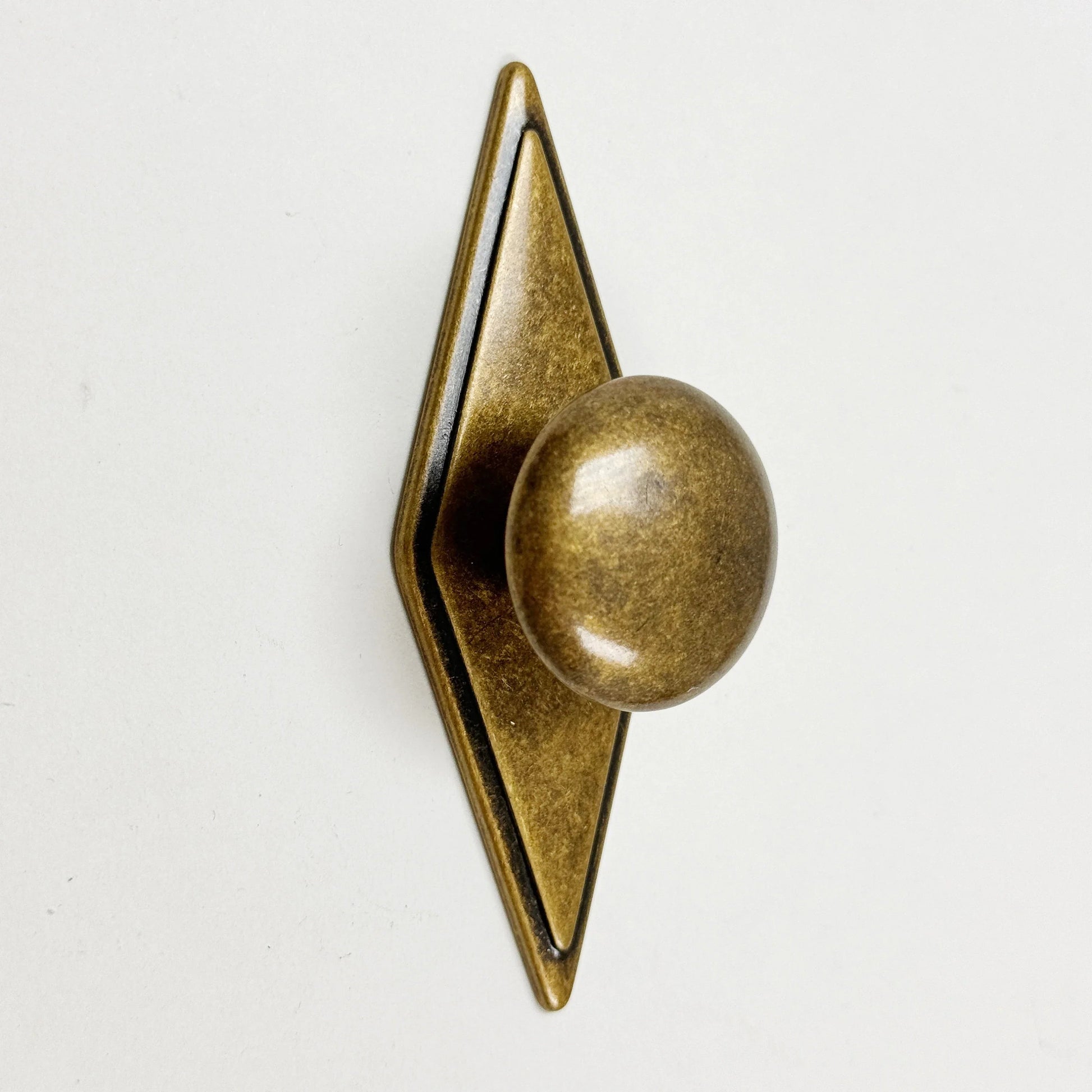 Bronze door knocker with geometric design on a white background