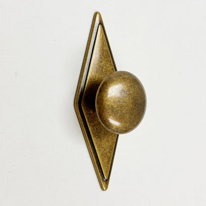 Bronze door knocker with geometric design on a white background