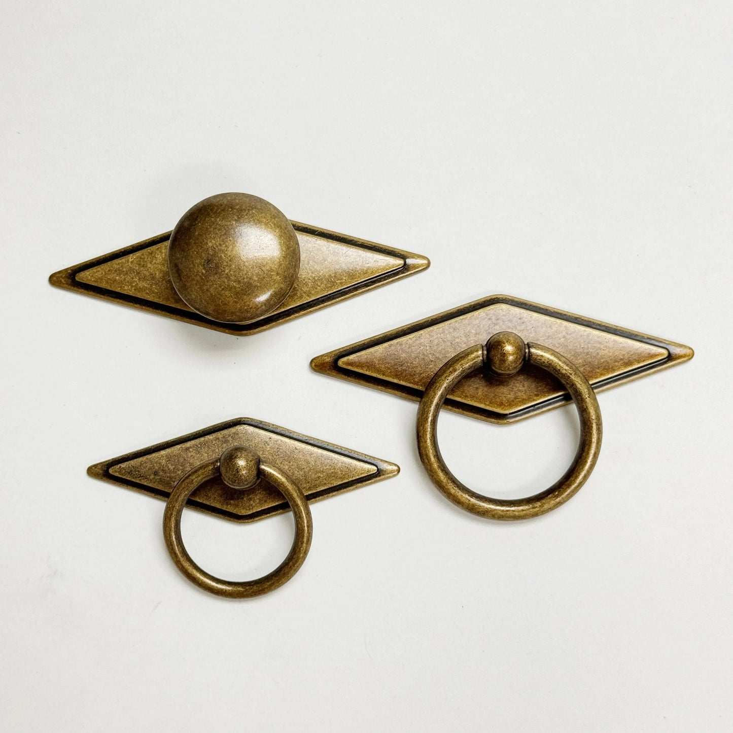 Set of three bronze cabinet knobs on a white background