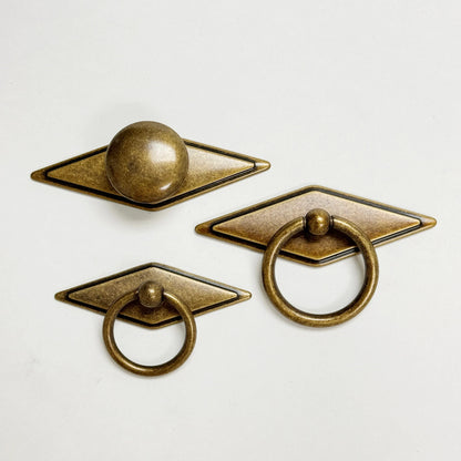 Set of three bronze cabinet knobs on a white background