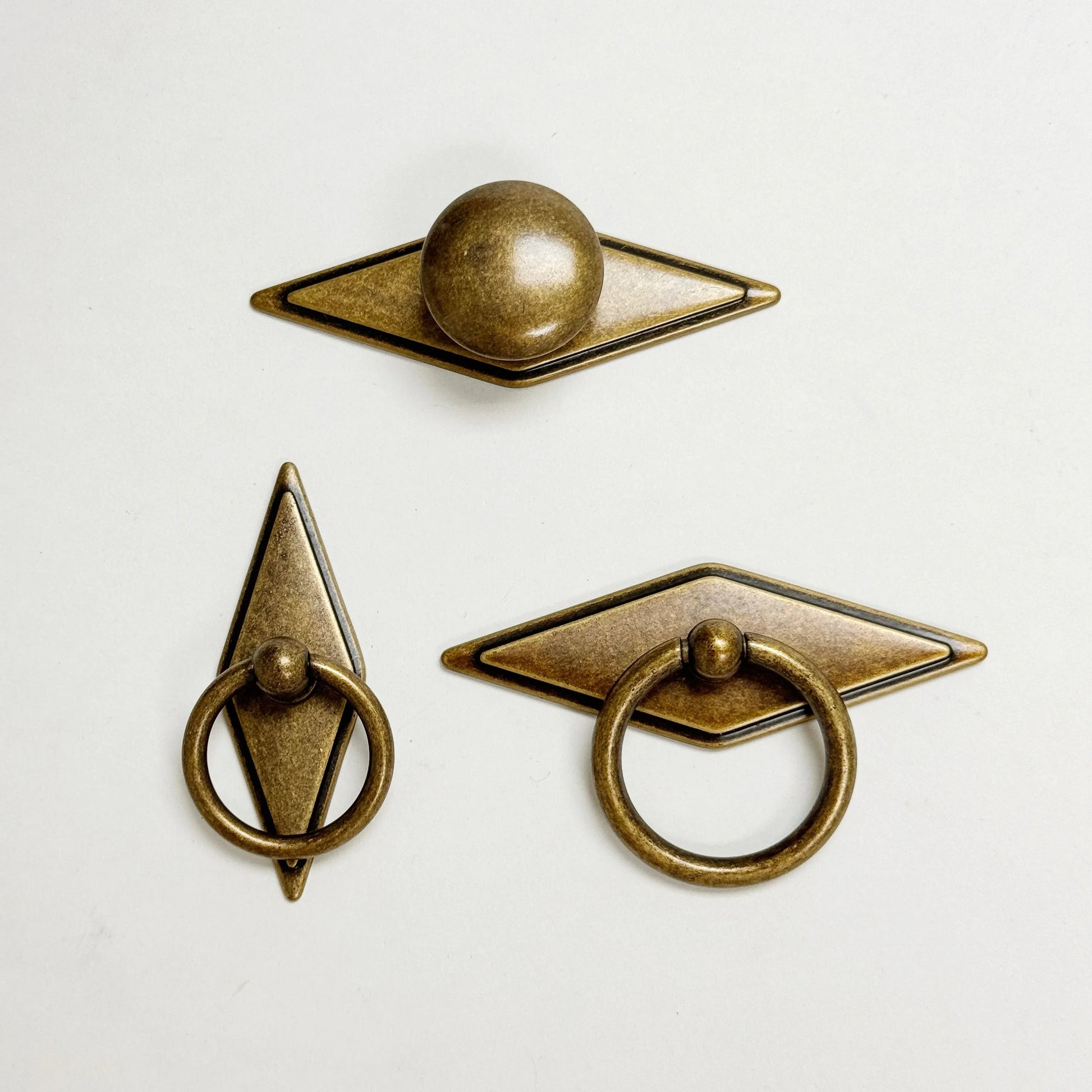Three bronze door handles on a white background