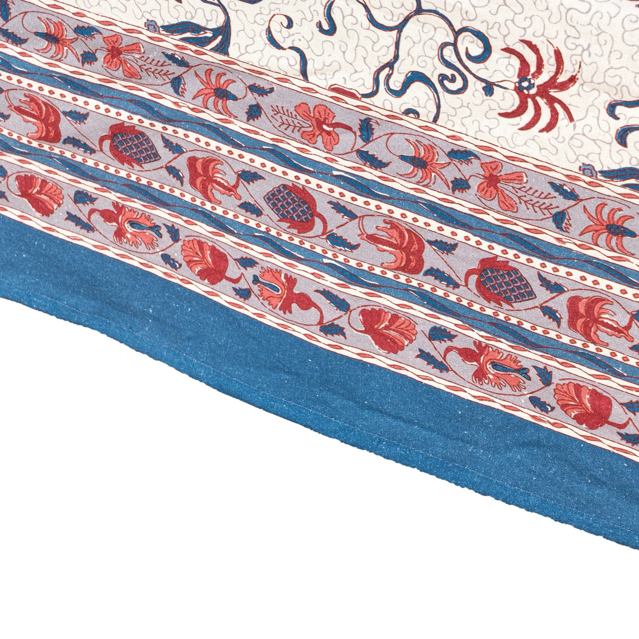 Close-up of a patterned fabric with red, blue, and white colors on a white background.