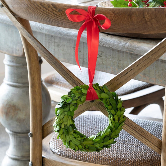 Green wreath with a red ribbon on a wooden chair