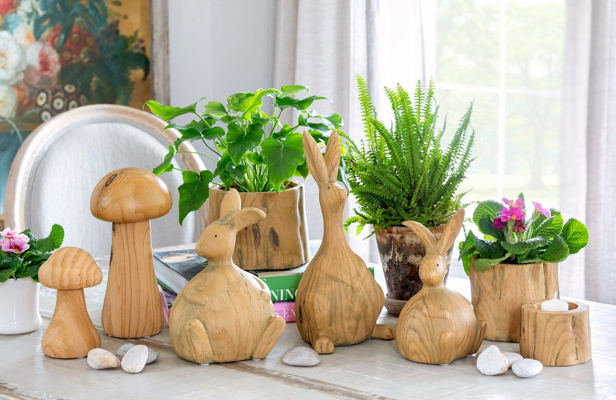 Wooden rabbit and mushroom decorations with plants on a table