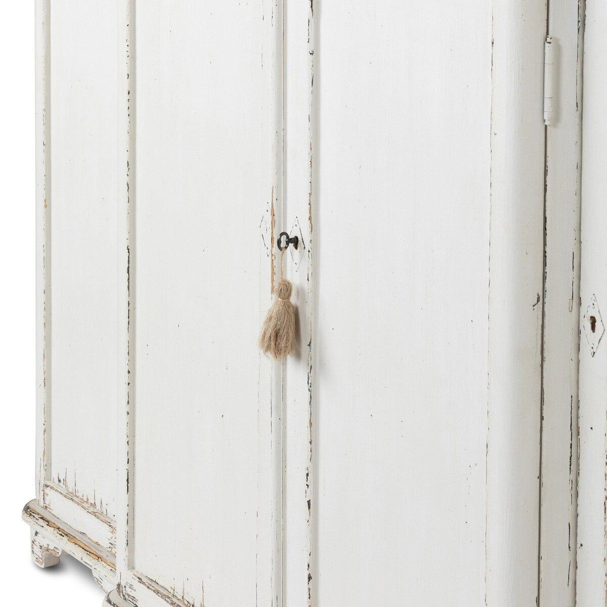 White distressed armoire with a tassel on a white background
